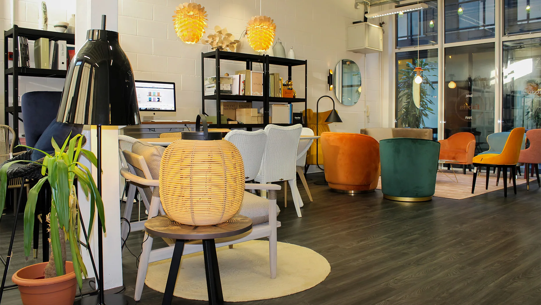 a well-lit room with a floor lamp, rattan lamp, and stylish upholstered armchairs and dining chairs